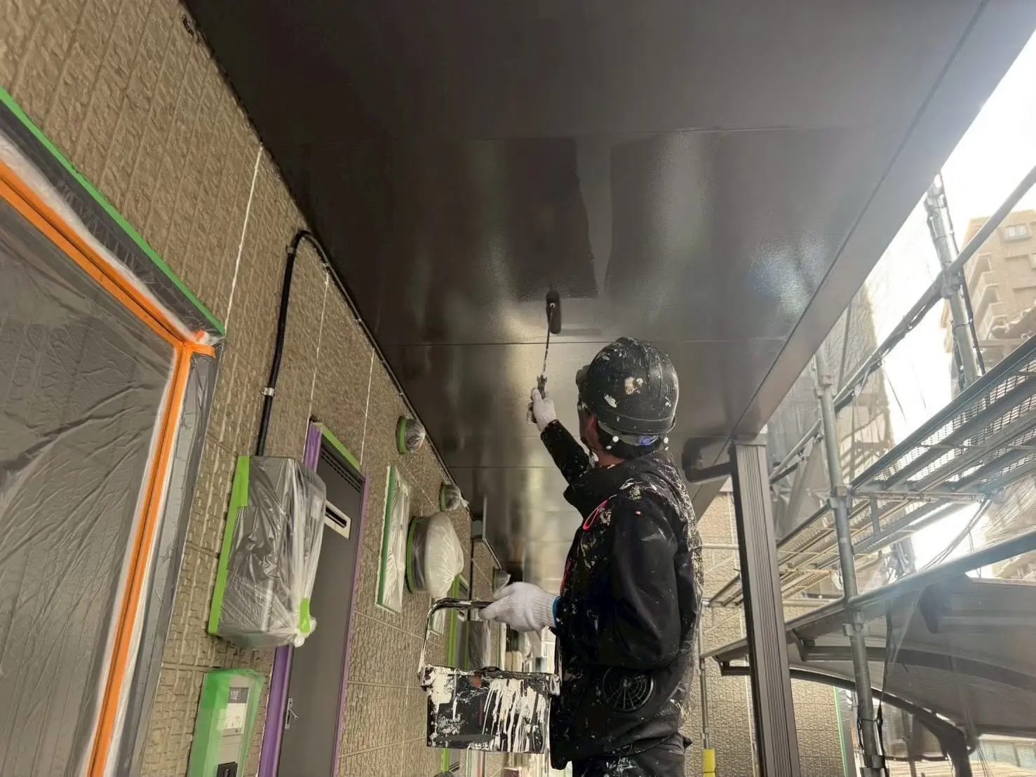 軒天を塗装する職人